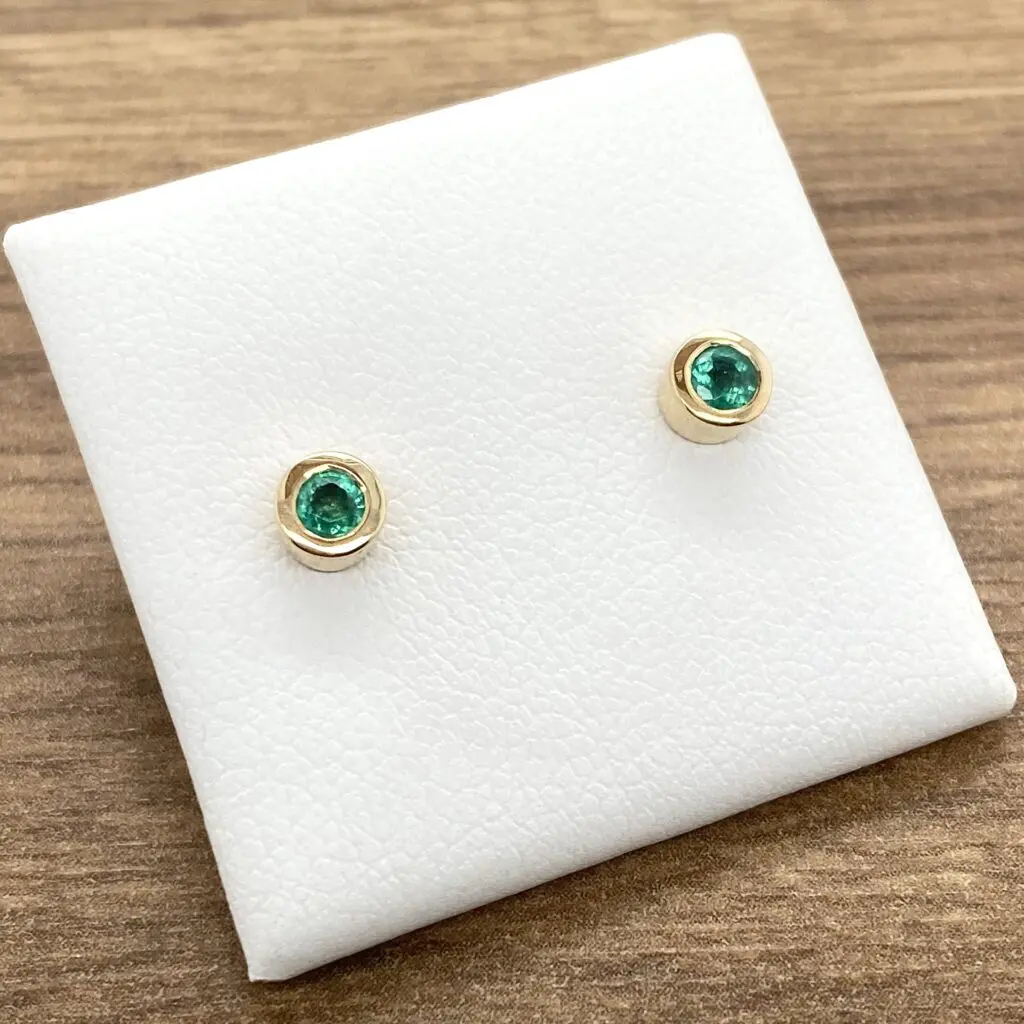 Emerald and gold stud earrings.