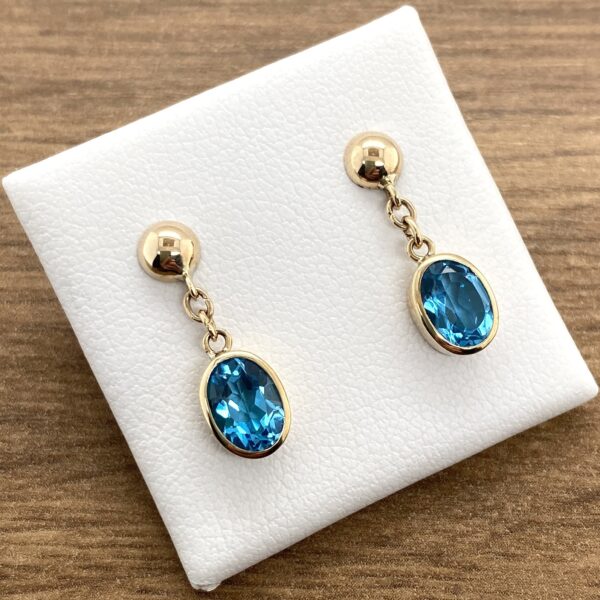 Oval blue topaz gold earrings.