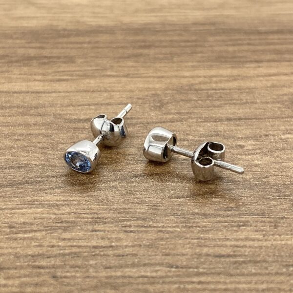 Silver stud earrings with blue stones.