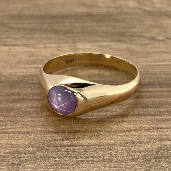 Gold ring with purple star sapphire.