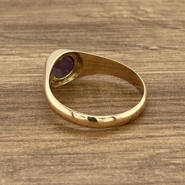 Gold signet ring with purple stone.