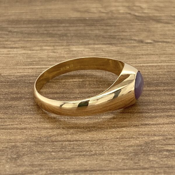 Gold signet ring with purple stone.