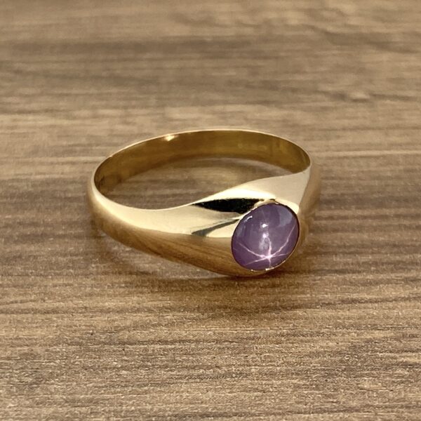 Gold ring with purple star sapphire.