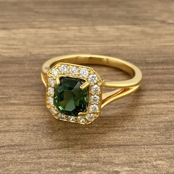 Gold ring with green gemstone and diamonds.