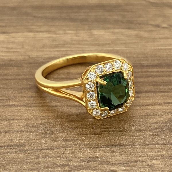 Gold ring with green gemstone and diamonds.