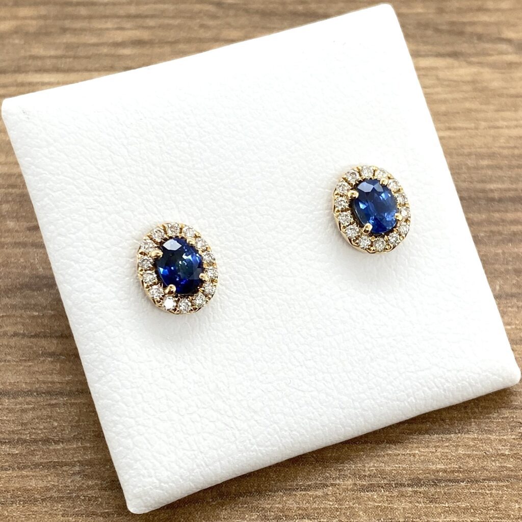 Gold earrings with blue gemstones on display.