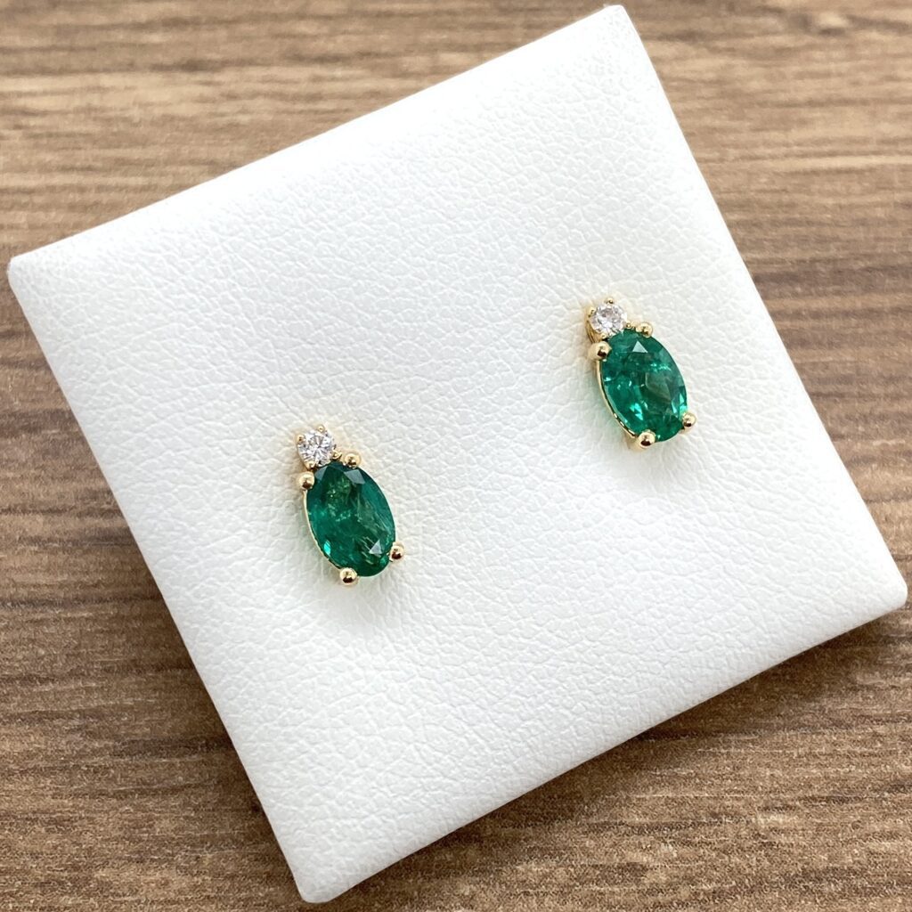 Emerald and diamond earrings on display.
