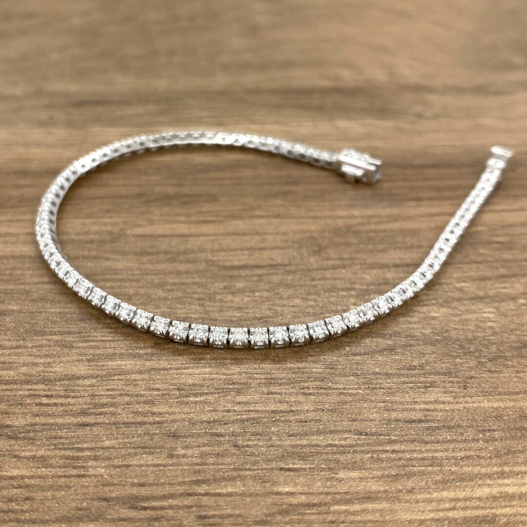 Diamond tennis bracelet on wooden surface.
