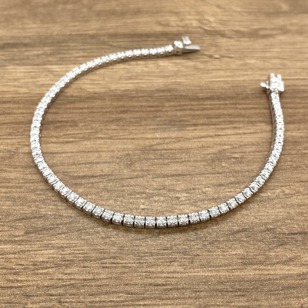 Diamond tennis bracelet on wooden surface.