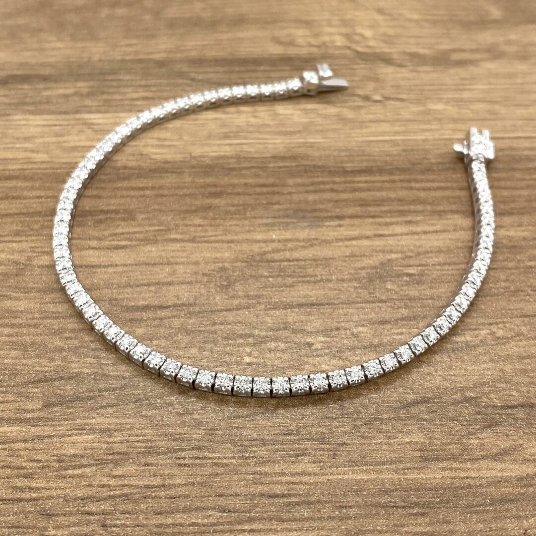 Diamond tennis bracelet on wooden surface.