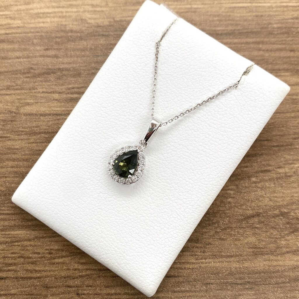 Teardrop pendant necklace on white display.