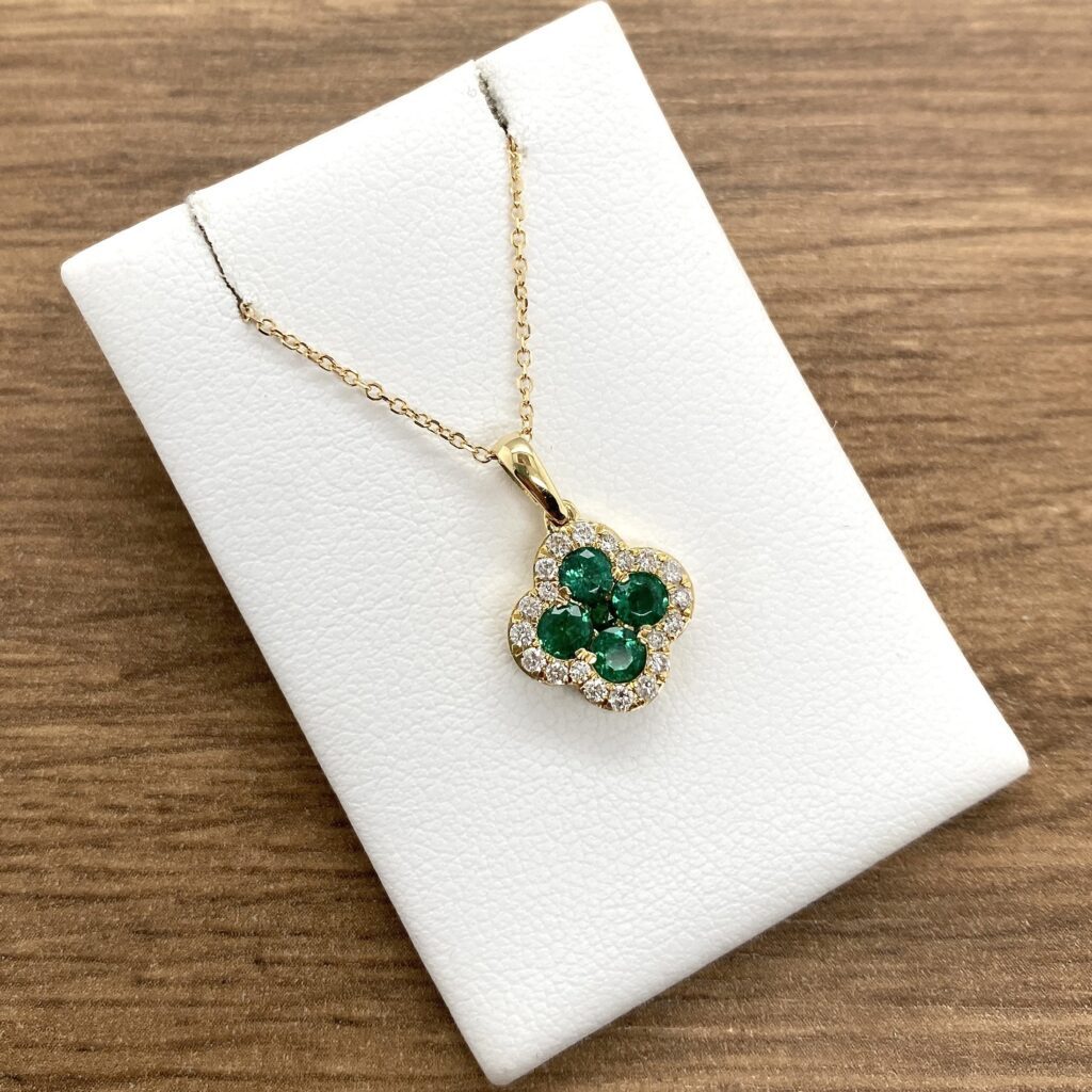 Gold necklace with green gemstone pendant.