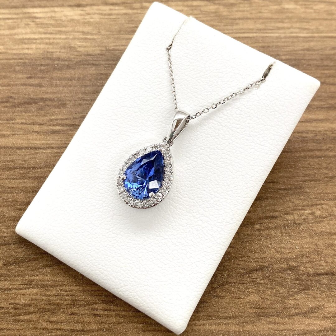 Blue teardrop pendant necklace on display.